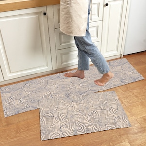 Könnte beinhalten: Zwei Küchenvorleger mit einem abstrakten Muster in Blau und Weiß. Die Vorleger sind aus einem weichen, saugfähigen Material gefertigt und eignen sich perfekt, um Ihrer Küche einen Hauch von Stil zu verleihen.