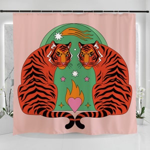 K&ouml;nnte beinhalten: Ein rosa Duschvorhang mit zwei orangefarbenen Tigern mit schwarzen Streifen, die sich gegen&uuml;berstehen. Die Tiger sind vor einem gr&uuml;nen Hintergrund mit Sternen, einem Sternschnuppen, einer Flamme und einem rosa Herzen platziert.
