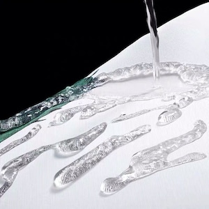 May include: Water droplets beading on a white fabric surface, demonstrating its water-resistant properties.