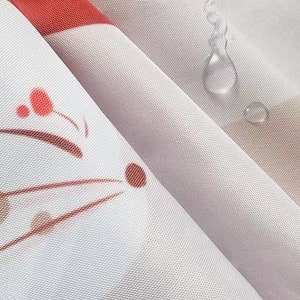K&ouml;nnte beinhalten: Nahaufnahme eines wei&szlig;en Stoffes mit rotem Streifen und floralem Design. Der Stoff hat eine subtile Textur und ist leicht gefaltet, mit Wassertropfen auf der Oberfl&auml;che. Das Design umfasst braune und rote florale Elemente.