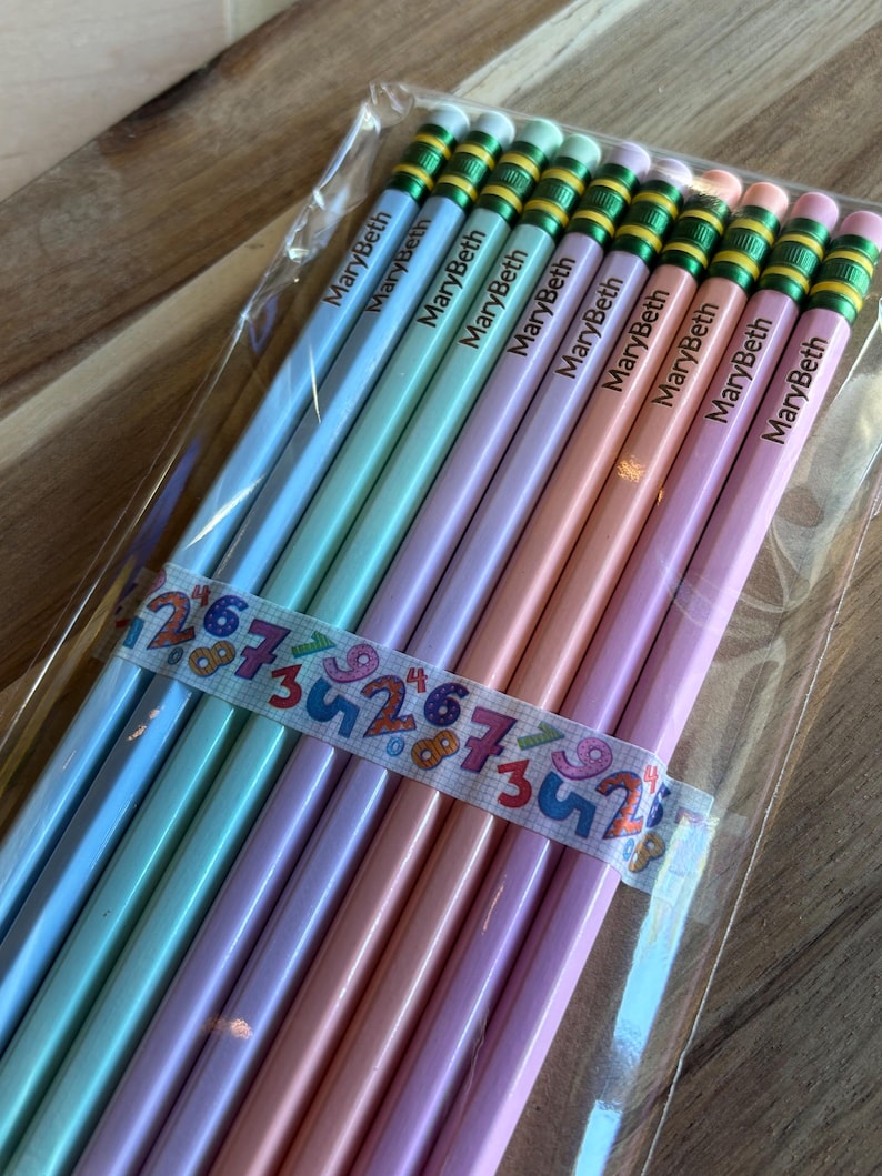 May include: A pack of ten personalized pencils with the name "MaryBeth" printed on each pencil. The pencils are in a variety of pastel colors, including light blue, light green, lavender, and pink. The pencils have green and yellow stripes near the eraser.