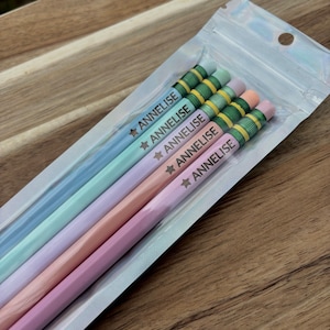 May include: Four pastel colored pencils with a green and yellow stripe and the name "Annelise" printed on each pencil.