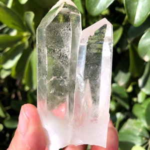 Peut inclure: Deux pointes de cristal de quartz transparent avec une légère teinte jaune. Les cristaux sont pointus en haut et ont une base plate.