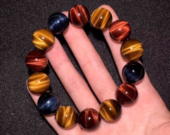 May include: A bracelet made of tiger's eye beads in red, gold, and blue colours.