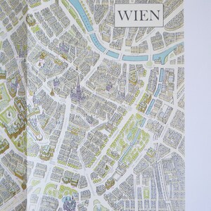 May include: A detailed map of Vienna, Austria, with the word "WIEN" printed in a white box at the top of the map. The map is drawn in a vintage style with blue and yellow lines and text.