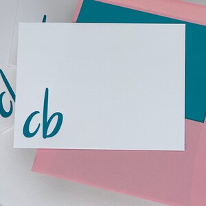 A letterpress notecard with monogram and pink lined envelope