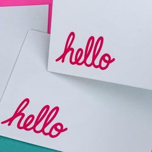 Two flat cards with the word hello printed in pink.
