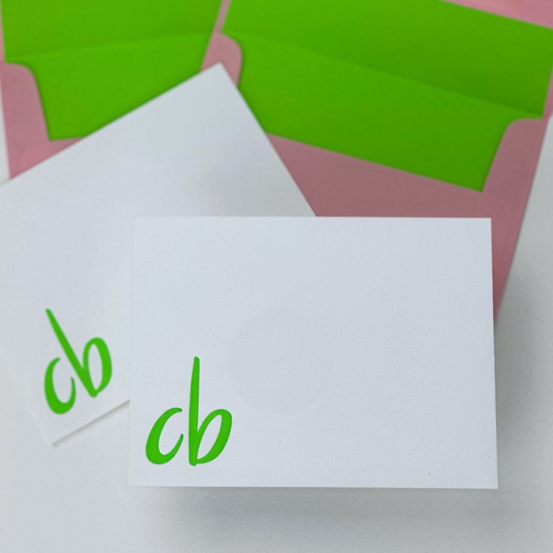 2 notecards printed in lime green ink with 2 pink envelopes lined in lime green paper