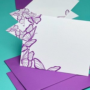 Letterpress printed notecards with purple butterflies and purple envelopes.