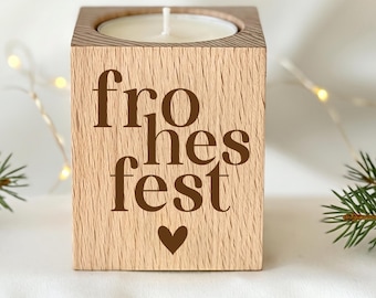 May include: A square wooden candle holder with a light brown grain finish. The front face features the dark brown text "fro hes fest" stacked in three lines, with a small heart symbol centered below the text. A white candle sits inside.