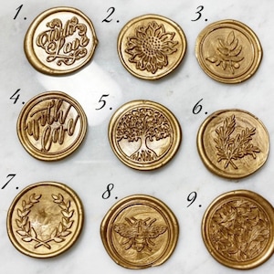 Op de afbeelding: Negen gouden waszegels met verschillende ontwerpen. De ontwerpen omvatten een ​​zonnebloem, een boom, een bij, bladeren en de woorden "with love".