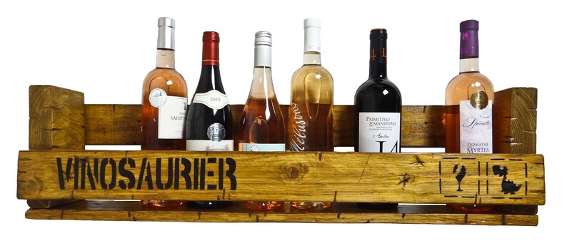 May include: A wooden wine rack with the word "VINOSAURIER" stenciled on the front. The rack holds six bottles of wine, including red, white, and ros&eacute;.