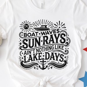 May include: White t-shirt with a black graphic design that says "Boat Waves Sun Rays Ain't Nothing Like Lake Days" with a boat, sun, and anchor.