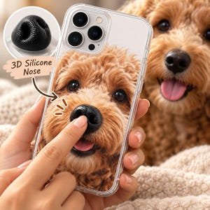 Pode incluir: Uma capa transparente para smartphone com uma imagem de alta resolução de um cão de pelo encaracolado castanho-dourado. A capa inclui um nariz de silicone 3D preto, texturizado e em relevo sobre o focinho, com o texto 3D Silicone Nose.