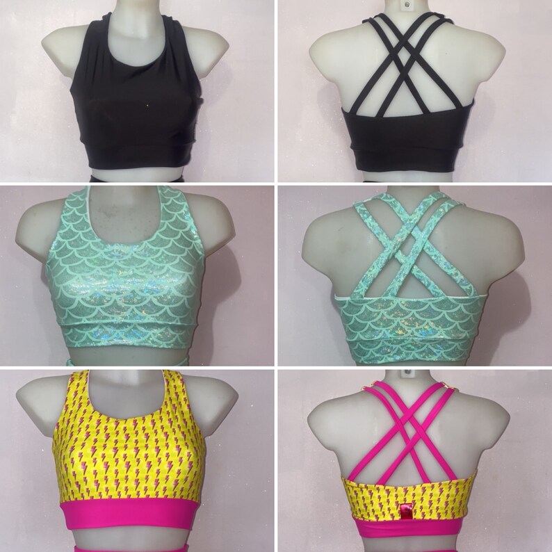 Op de afbeelding: Drie verschillende sportbeha's met verschillende patronen en rugbandjes. De eerste beha is zwart met een racerback-stijl. De tweede beha is teal met een zeemeermin-schubbenpatroon en gekruiste bandjes. De derde beha is geel met een bliksem-patroon en gekruiste bandjes.