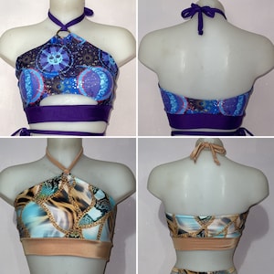 Pu&ograve; includere: Due top halter con motivi diversi. Il primo top ha una stampa celeste blu e viola con una fascia viola intorno al seno. Il secondo top ha una stampa a catena blu e oro con una fascia color sabbia intorno al seno.