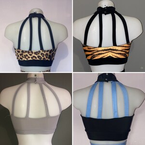 May include: Four different dance tops with a halter neck and criss-cross straps in the back. The tops are in black, gray, and a leopard print with black straps. The fourth top has a blue strap.