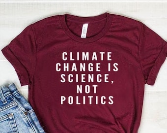 May include: A maroon t-shirt with the text "Climate Change is Science, Not Politics" printed in white.