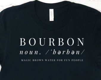 May include: Black t-shirt with white text that reads "BOURBON noun. /'bərbən/ MAGIC BROWN WATER FOR FUN PEOPLE"