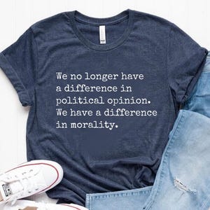 May include: A navy blue t-shirt with a white print that reads "We no longer have a difference in political opinion. We have a difference in morality."