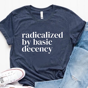 May include: A navy blue t-shirt with the text "radicalized by basic decency" in white lettering.