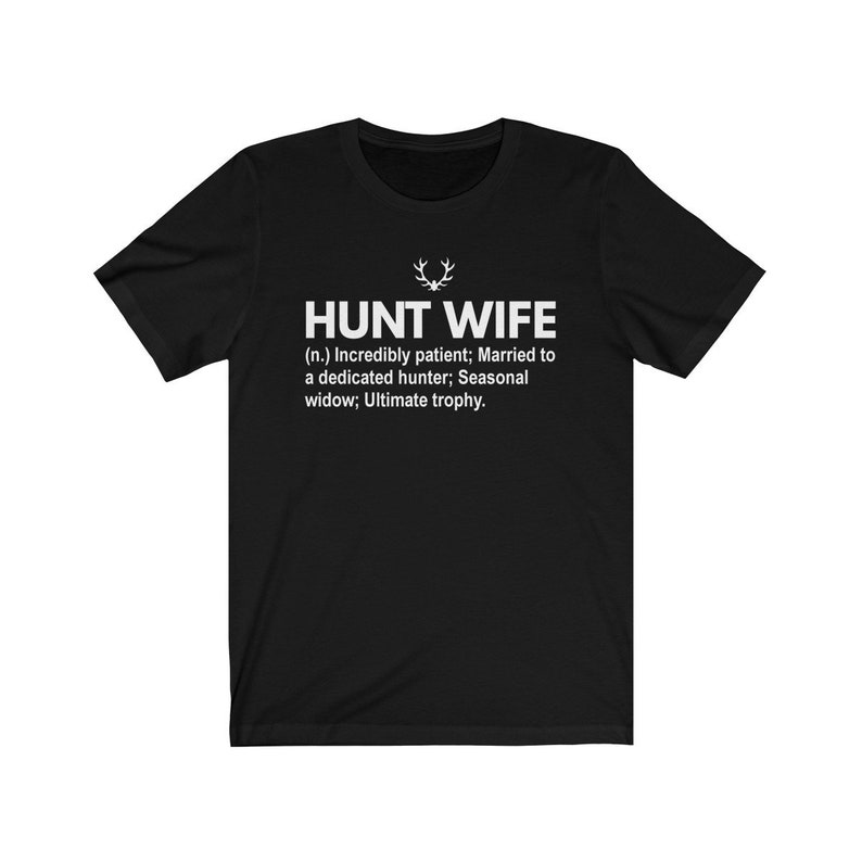 May include: Black t-shirt with white text that reads "HUNT WIFE (n.) Incredibly patient; Married to a dedicated hunter; Seasonal widow; Ultimate trophy."