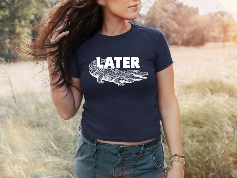 May include: A navy blue t-shirt with a white alligator graphic and the word "LATER" printed in white.