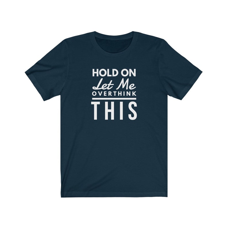 May include: A navy blue t-shirt with white text that reads "Hold on Let Me Overthink This".