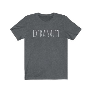 May include: A dark heather grey t-shirt with the text "EXTRA SALTY" printed in white.