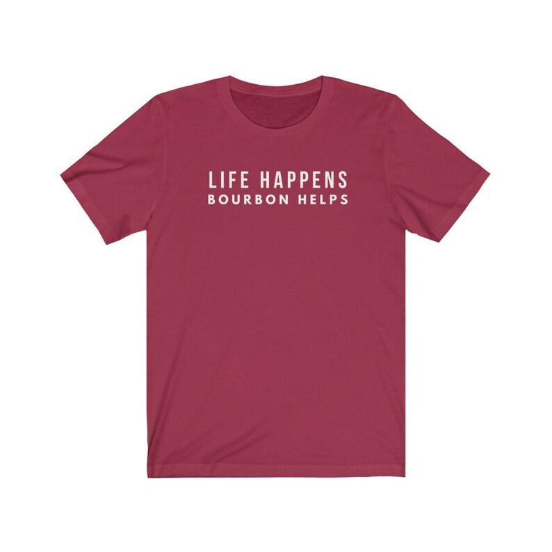 May include: A maroon short-sleeved t-shirt with the text "LIFE HAPPENS BOURBON HELPS" printed in white on the front.