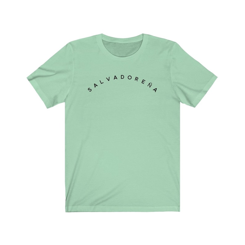 May include: A light green t-shirt with the text "SALVADORENA" printed in black on the front.