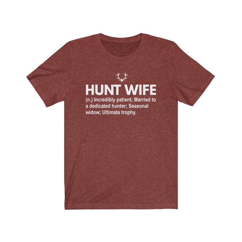 May include: Red t-shirt with white text that reads "HUNT WIFE (n.) Incredibly patient; Married to a dedicated hunter; Seasonal widow; Ultimate trophy."
