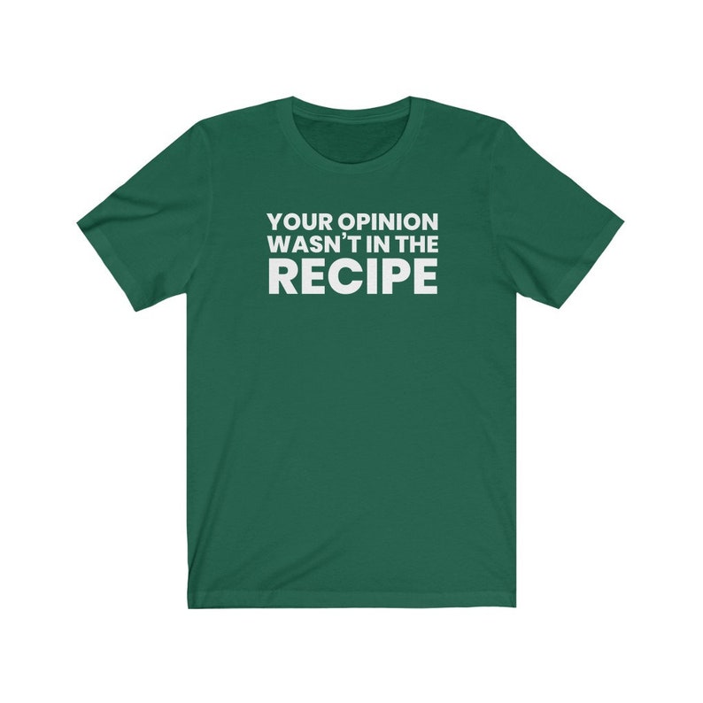 May include: A dark green short-sleeved t-shirt featuring the white text "YOUR OPINION WASN'T IN THE RECIPE" printed in a bold, sans-serif font across the centre of the chest. The garment has a crew neckline and a standard, straight-cut silhouette.