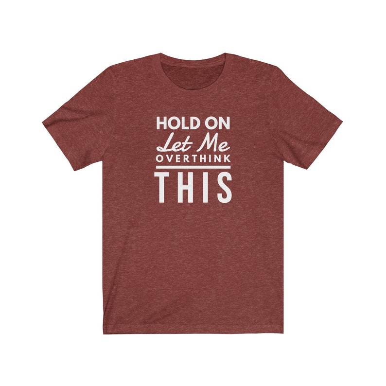 May include: Red heather t-shirt with white text that reads "Hold On Let Me Overthink This".