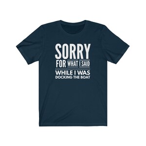 May include: A navy blue t-shirt with white text that reads "SORRY FOR WHAT I SAID WHILE I WAS DOCKING THE BOAT".