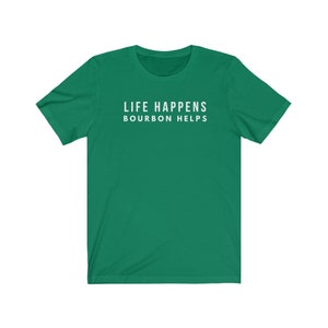 May include: A green t-shirt with the text "Life Happens Bourbon Helps" printed in white on the front.