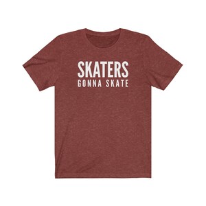 May include: A maroon heather t-shirt with white text that reads "SKATERS GONNA SKATE".