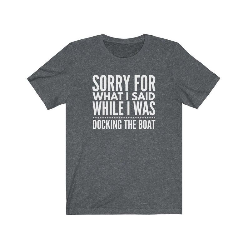 Op de afbeelding: Donkergrijs T-shirt met de witte tekst: "SORRY FOR WHAT I SAID WHILE I WAS DOCKING THE BOAT". Het T-shirt heeft een ronde hals en is waarschijnlijk gemaakt van een zachte stof. Een humoristisch kledingstuk.