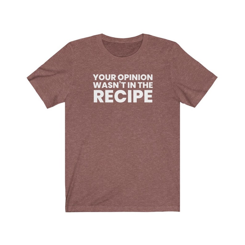 May include: A heathered maroon short-sleeved t-shirt featuring the white text "YOUR OPINION WASN'T IN THE RECIPE" printed in a bold, sans-serif font across the centre of the chest. The garment has a crew neckline and a standard fit.