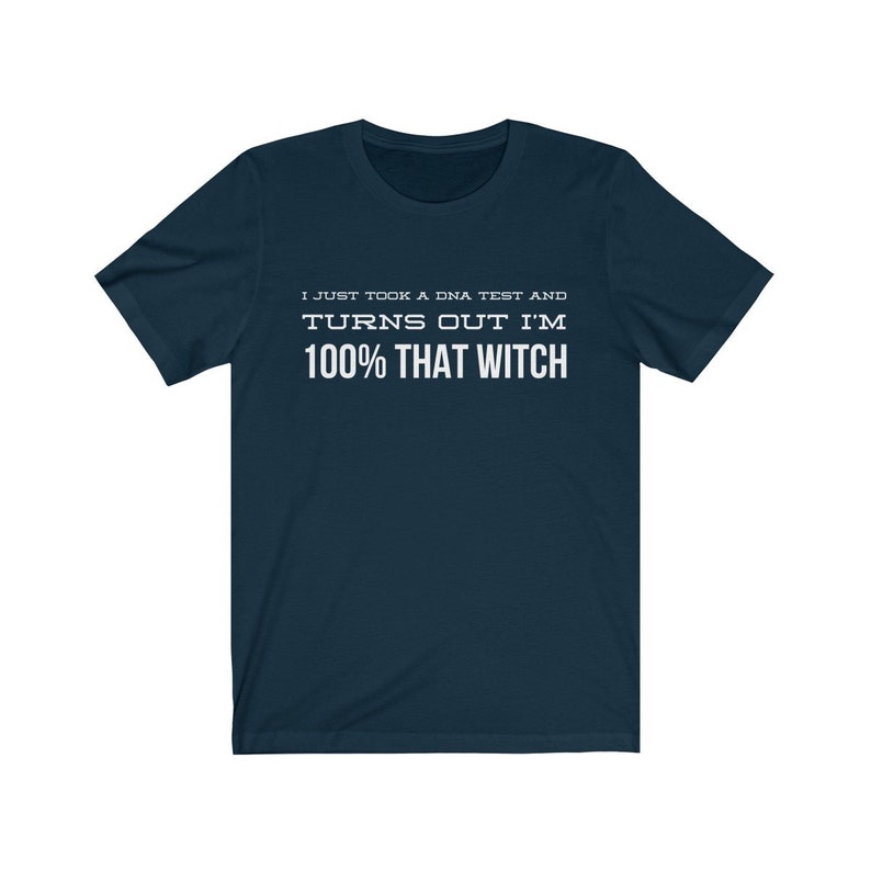 May include: A dark navy blue short-sleeve t-shirt featuring white text printed on the chest that reads: I JUST TOOK A DNA TEST AND TURNS OUT I'M 100% THAT WITCH. The garment has a crew neckline and a standard fit with short sleeves.