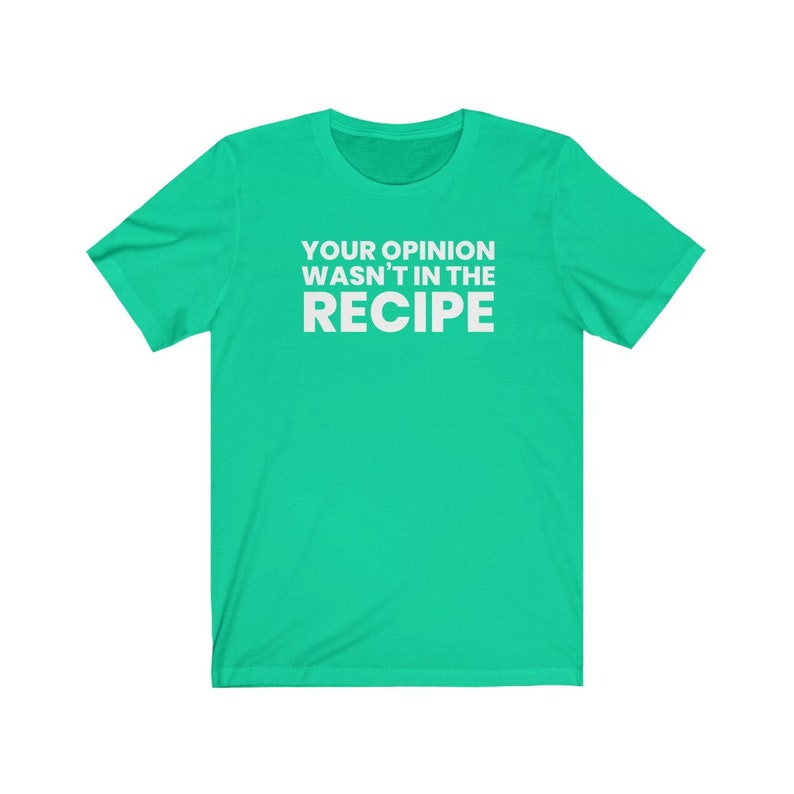 May include: A bright green short-sleeved t-shirt featuring the white text "YOUR OPINION WASN'T IN THE RECIPE" printed in a bold, sans-serif font across the centre of the chest. The garment has a crew neckline and a standard, casual fit.