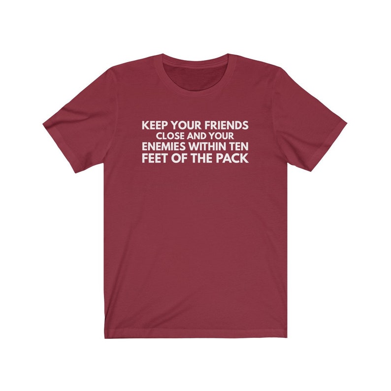 May include: Burgundy t-shirt with white text that reads "Keep your friends close and your enemies within ten feet of the pack."