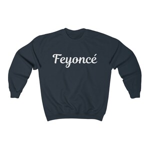K&ouml;nnte beinhalten: Ein marineblauer Pullover mit dem Aufdruck "Feyonc&eacute;" in Wei&szlig; auf der Vorderseite.