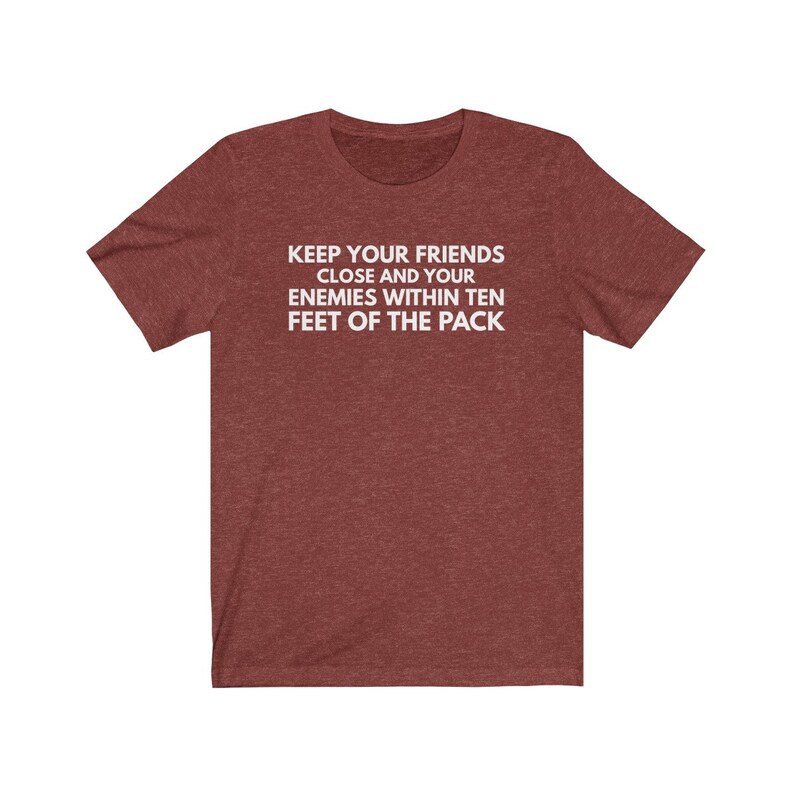 May include: A maroon heather t-shirt with the text "KEEP YOUR FRIENDS CLOSE AND YOUR ENEMIES WITHIN TEN FEET OF THE PACK" printed in white.