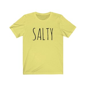 May include: A yellow short-sleeved t-shirt with the word "SALTY" printed in black on the front.