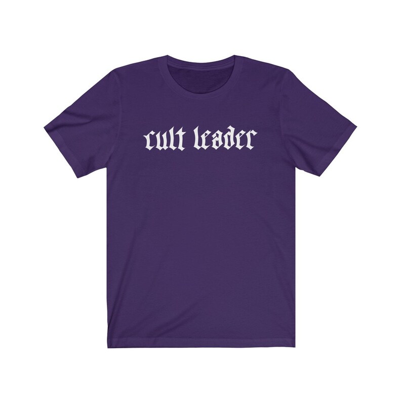 May include: A purple short-sleeved t-shirt with the text "cult leader" in white gothic lettering.