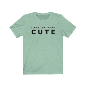 May include: A light green t-shirt with the text "Cabrona pero cute" in black.