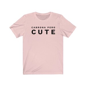 May include: A pink t-shirt with the text "Cabrona pero cute" in black.
