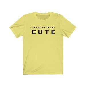 May include: A yellow t-shirt with black text that reads "Cabrona pero cute".