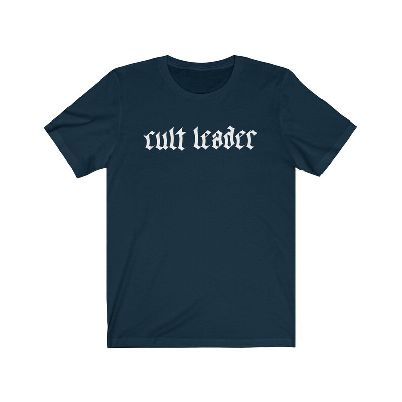 May include: A dark blue t-shirt with the text "cult leader" printed in white on the front.